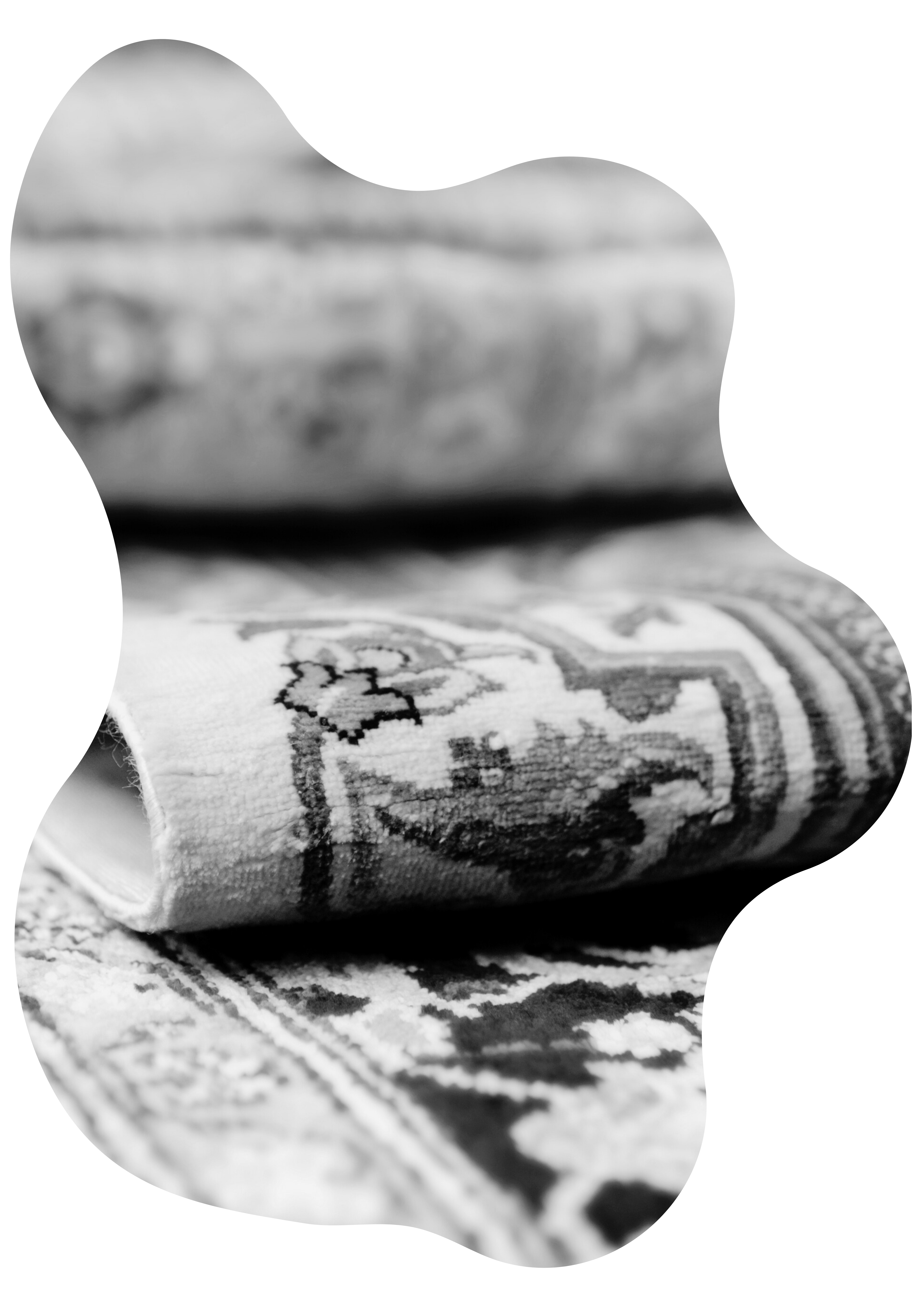 Nahaufnahme eines kunstvoll gemusterten, gefalteten Teppichs – Symbol für die Expertise und Tradition von Fein und Rein in der Textilpflege.